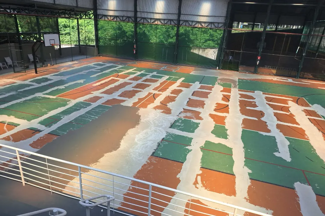Antes: A quadra tinha pintura soltando em placas sobre o contrapiso, com áreas de cor completamente diferentes umas d