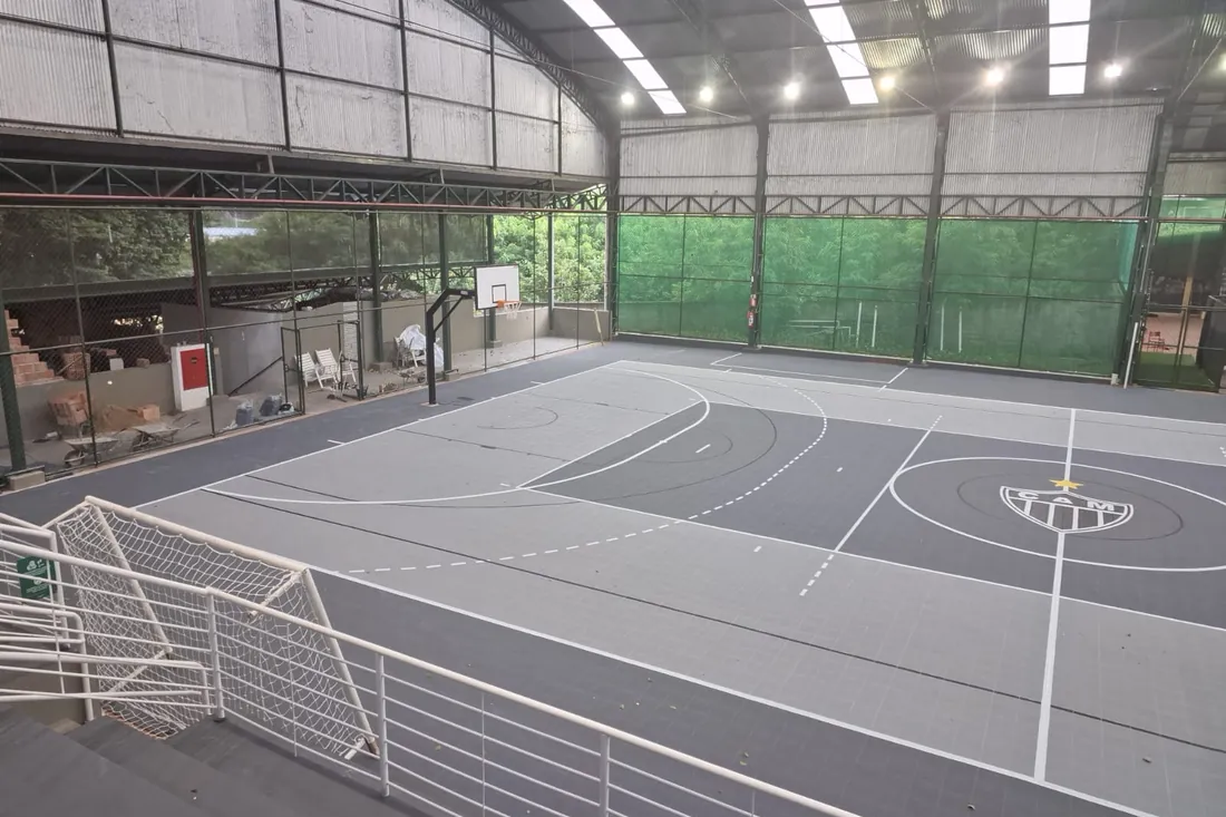 Depois: Piso modular assentado com marcação esportiva e escudo do clube executados no próprio material, sem camada de 